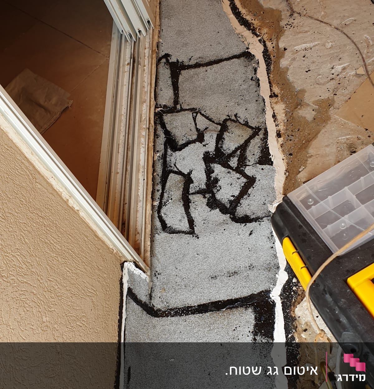 איטום רצפה עם חומר שחור ולבן ליד דלת הזזה